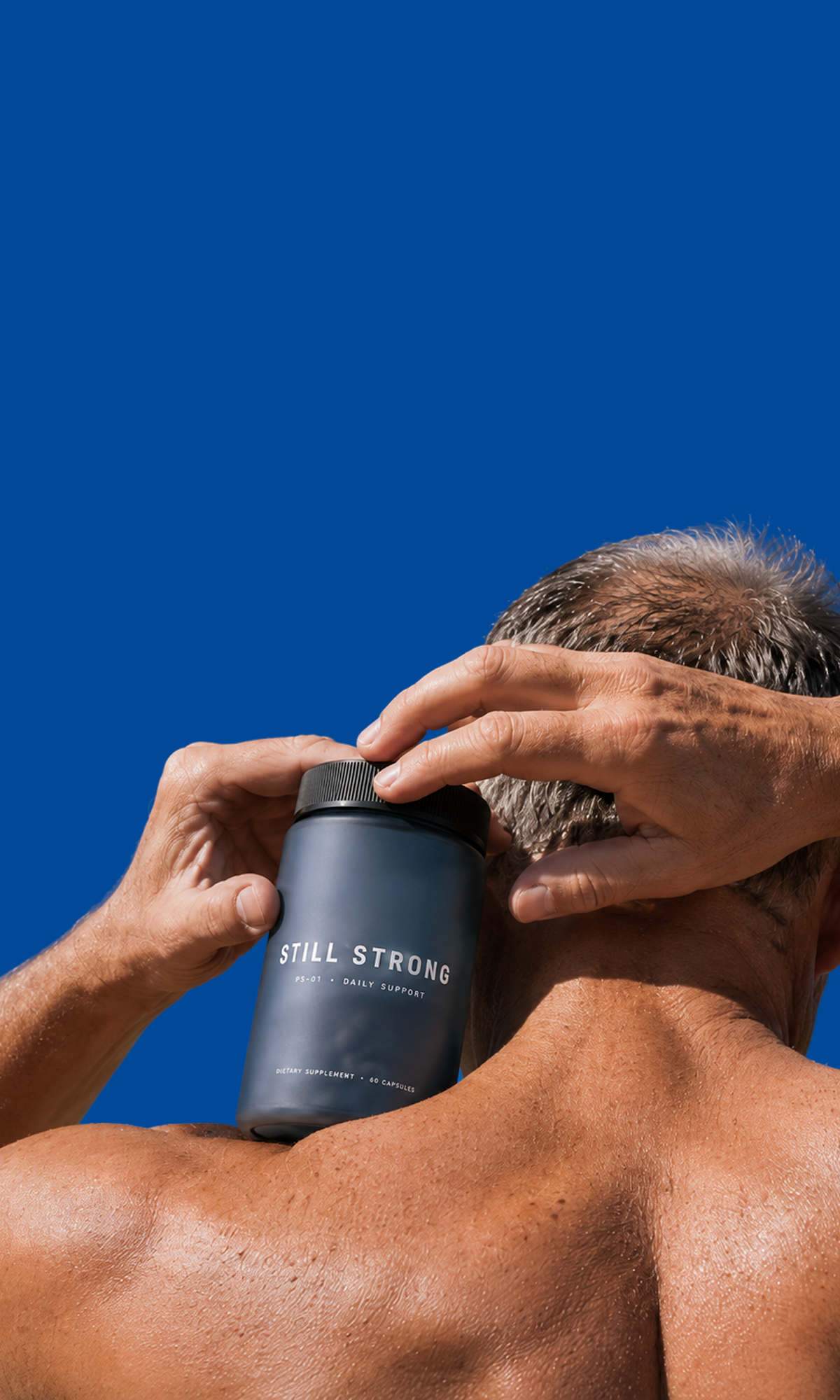 Man holding the Still Strong supplement bottle